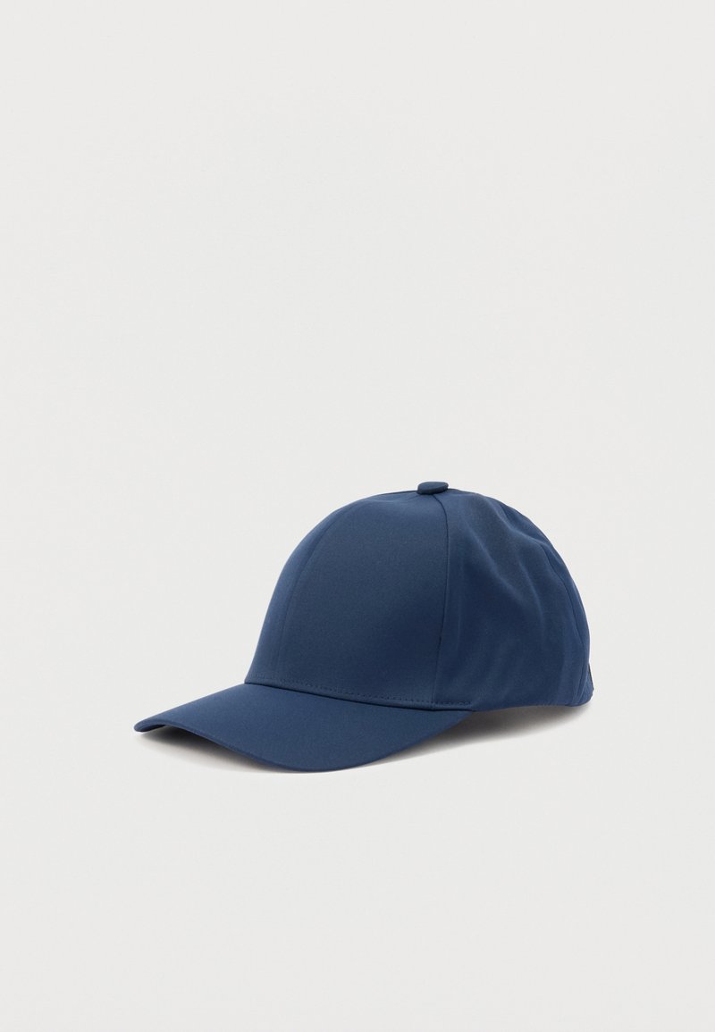 Σκούφος του μπέιζμπολ σε σκούρο μπλε χρώμα με καμπύλη γείσο και κουμπί στην κορυφή, τοποθετημένος σε απλό ανοιχτό γκρι φόντο.