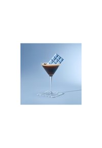 Klar glasscocktailglass med en brun væske, toppet med et lett skum; et lys blått, geometrisk mønstrete kort hviler på kanten.