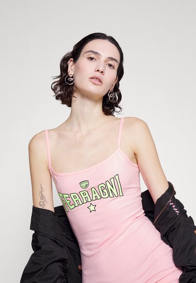 Ροζ χωρίς μανίκια φόρεμα από ελαστικό υλικό, με έντονη εκτύπωση "FERRAGNI" και λεπτομέρεια αστεριού. Συμπληρωμένο με μια μαύρη ζακέτα.