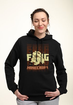 Black hoodie with a Minecraft-themed graphic, featuring a light green character, geometric patterns, and the word "Minecraft" in orange.