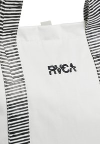 White tote bag with black striped handles. Features embroidered RVCA logo on the front. Material appears durable and lightweight.