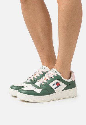 Sneaker verdi e bianche con una superficie in pelle testurizzata, lacci rosa, patch con logo e punta perforata; design low-top.
