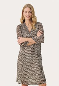 Black and brown zigzag-patterned dress with a collar and three-quarter sleeves, made of sheer material, featuring a relaxed fit.