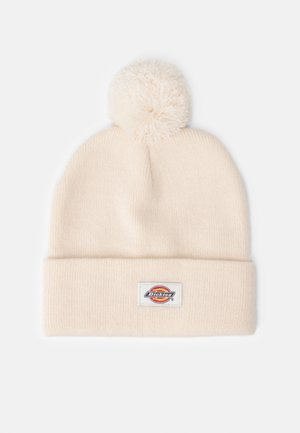 Bonnet tricoté de couleur crème avec un gros pompon sur le dessus et un revers plié ornée d'un patch logo Dickies.