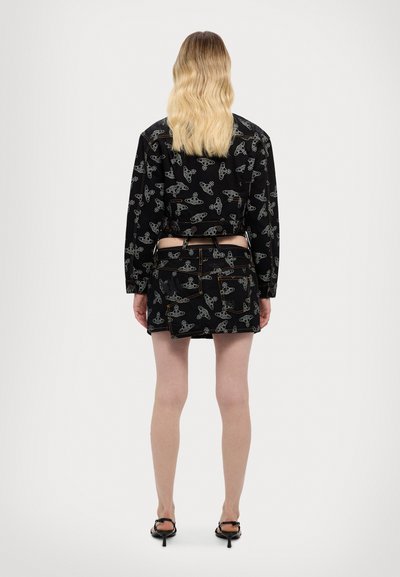 Black outfit featuring a cropped shirt and short skirt with a repeating light-colored abstract pattern. Smooth fabric with a fitted design.