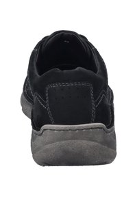 Czarne zamszowe trampki z szarą gumową podeszwą, o zaokrąglonym kształcie, z podwójnymi przeszyciami oraz perforacjami z tyłu dla lepszej wentylacji.