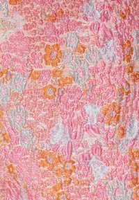 Tissu tissé présentant un motif floral dans des teintes de rose, orange et argent avec une finition texturée, mettant en valeur des détails et une profondeur complexes.