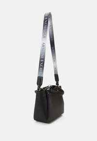 Schwarze Leder-Eimerhandtasche mit glatter Textur, ausgestattet mit einem abnehmbaren Tragegurt, der mit dem Schriftzug "Armani Exchange" in Farbverlauf verziert ist.