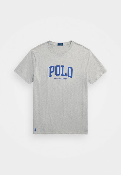 Pelēks īsām piedurknēm T-krekls, izgatavots no kokvilnas. Uz krūšu daļas ir zils "POLO RALPH LAUREN" logs, kā arī neliels zils logs apakšmalā.