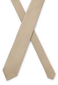 Vaaleanbeige solmio, jossa on teksturoitu kuvio ja kapea leveys sekä terävä kärki. Materiaali näyttää olevan kudottu hienovaraisilla geometrisilla yksityiskohdilla.