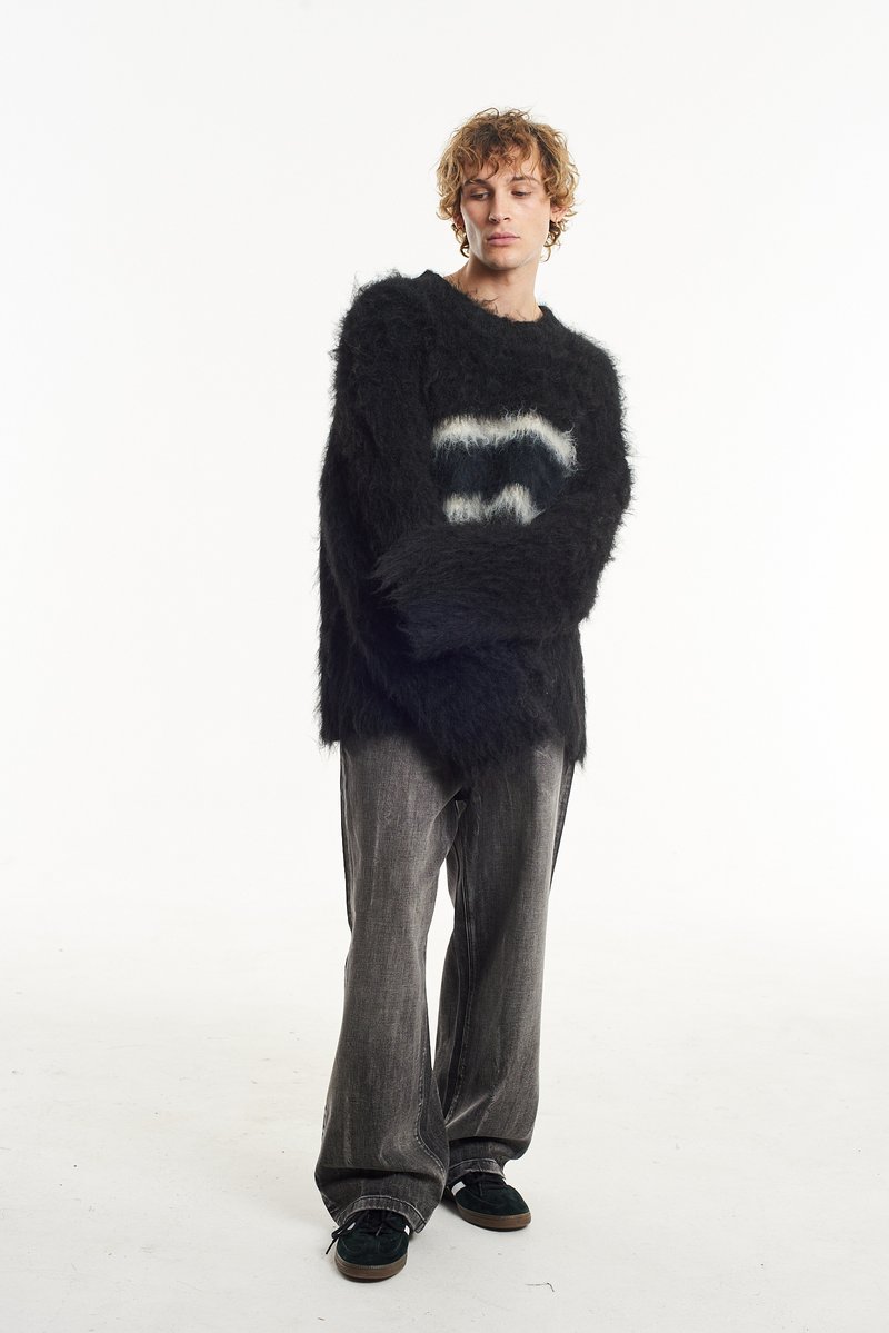 Black fuzzy sweater with a white and grey wave pattern, paired with loose grey jeans and green shoes. Soft texture, oversized design.