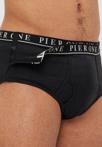 Schwarze Baumwollunterhosen mit einem kontrastierenden elastischen Bund, der "PIER ONE" in weißen Buchstaben zeigt. Glatte Textur und taillierter Schnitt.
