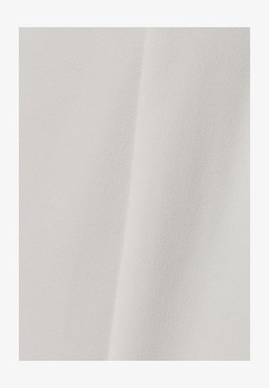 Měkká, texturovaná tkanina v odstínu krémové barvy s hladkým povrchem a mírným leskem, vykazující jemné variace v tónu a odrazu světla.