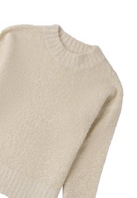 Suéter color crema con una apariencia texturizada y suave. Presenta un cuello redondo acanalado y mangas largas.