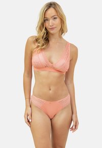 Ensemble de bikini deux pièces en corail doux, avec des détails en dentelle texturée et des motifs géométriques ; style bralette avec bretelles ajustables, bas assortis.