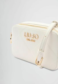 Borsa a tracolla in pelle bianca con hardware dorato, caratterizzata da un design trapuntato, chiusura con cerniera e tracolla regolabile. Logo "LIU·JO MILANO" in evidenza.