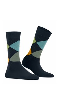 Skarpetki w wzory, w których dominują ciemnoniebieskie, zielone, jasnoniebieskie, szare i pomarańczowe kształty w romby; wyeksponowane stojące obok siebie na białym tle.