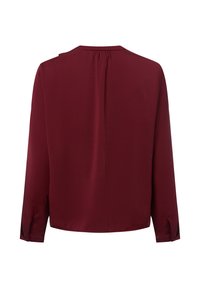 Bordeauxfarbene Bluse mit langen Ärmeln in lässiger Passform, Rundhalsausschnitt, Rückenfalte und knöpfbaren Manschetten. Glattes, ungemustertes Material.