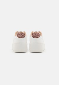 Weiße Sneaker mit einer strukturierten Oberfläche und einer dicken Sohle, ausgestattet mit einem beigen Fersenbereich im Leopardenmuster. Klassisches Schnürdesign.