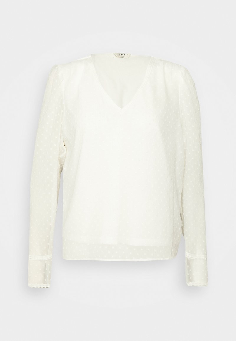 White long-sleeve blouse with a V-neck, featuring a dotted pattern and lace trim at the cuffs. Soft, textured fabric with a relaxed fit.