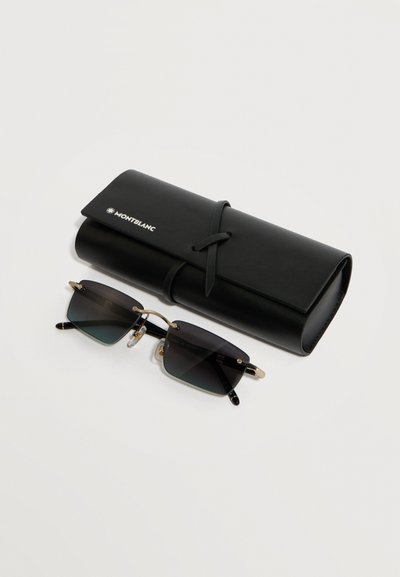 Μαύρα ορθογώνια γυαλιά ηλίου με χρυσές λεπτομέρειες, τοποθετημένα δίπλα σε ένα μαύρο κυλινδρικό δερμάτινο θήκη Montblanc με δέσιμο με κορδόνι, πάνω σε λευκό φόντο.