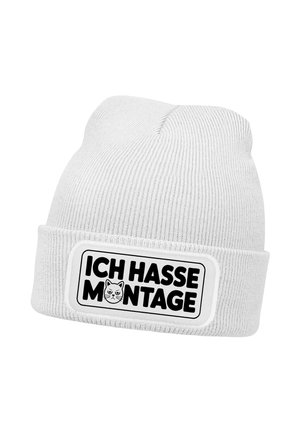 Weiß gestrickte Mütze mit umgeschlagenem Bündchen, versehen mit einem Aufnäher mit der Aufschrift "ICH HASSE MONTAGE" und einem kleinen Symbol eines wütenden Katzenkopfs.