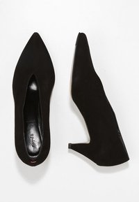 Escarpins en daim noir à bout pointu avec un design ajouré et un petit talon bloc. Présentent une doublure intérieure lisse et un accent rouge subtil.