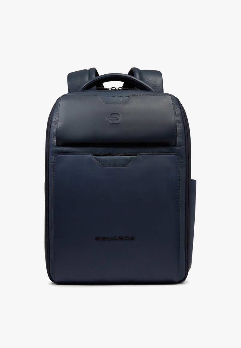 Sac à dos en cuir bleu marine avec poche avant zippée, poignée supérieure, bretelles rembourrées et logo de marque subtilement embossé sur le panneau avant.