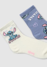 Bawełniane skarpetki w kolorze białym i niebieskim. Biała skarpetka ozdobiona jest postacią z kreskówki z napisem "STITCH"; niebieska skarpetka ma jasne wzory i akcenty postaci.