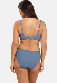 Ensemble de lingerie bleu foncé composé d'un tissu lisse et extensible. Comprend des bretelles réglables et un bas de bikini taille haute avec des bords cousus.