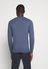Męski sweter z długim rękawem w ciemnym niebieskim kolorze, o dzianinowej fakturze, z dekoltem w kształcie zaokrąglonego kołnierza, z prążkowanymi mankietami i krawędzią, gładkim wykończeniem, jednolity design bez wzorów.