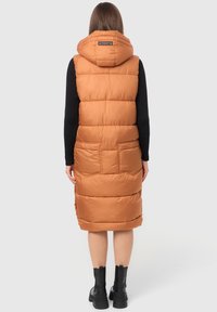 Pufferväst i bränd orange, med huva, framfickor och en lång design. Slät textur med quiltade sektioner och hög krage.