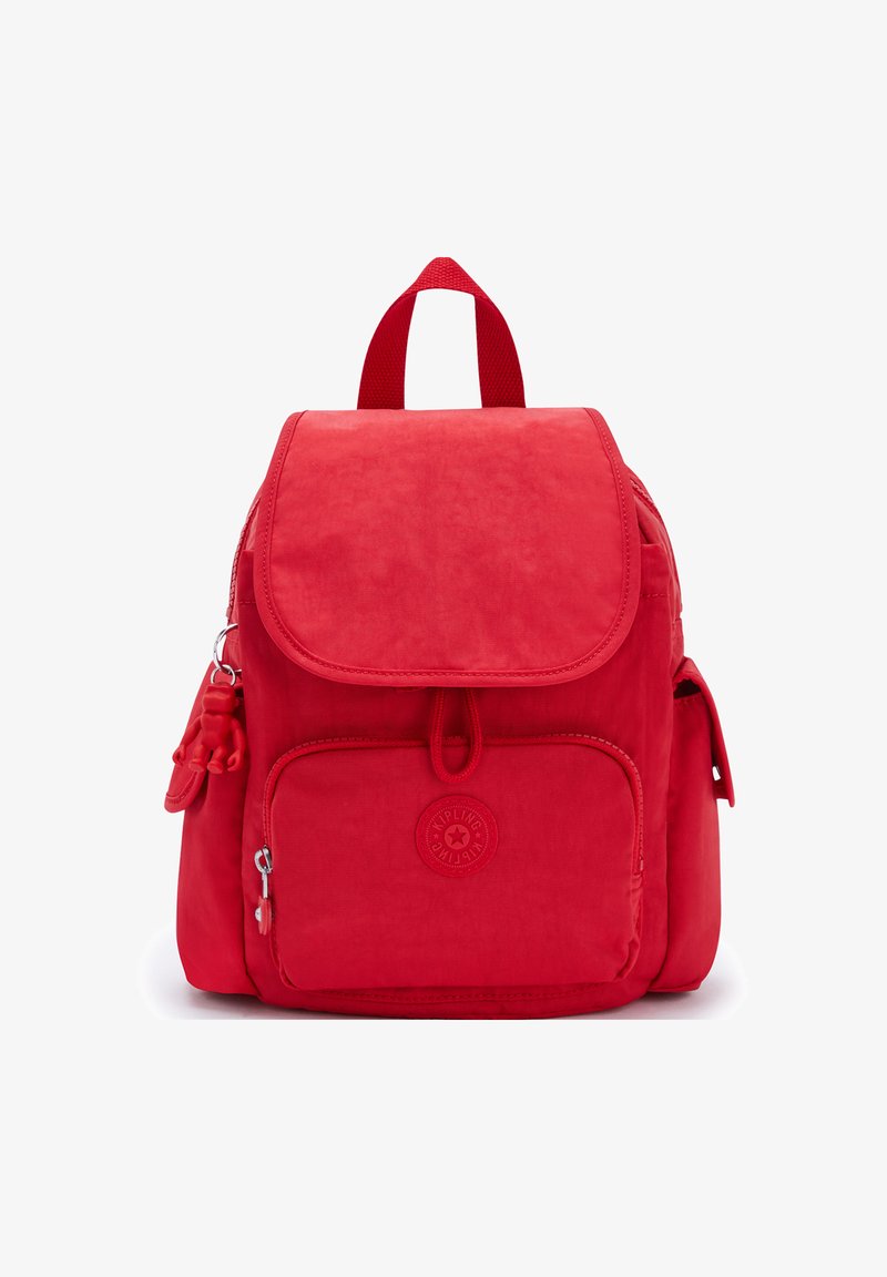 Zaino rosso in nylon con chiusura a patta, tasca frontale con zip e tasche laterali. Presenta una finitura testurizzata e un piccolo portachiavi a forma di scimmia.