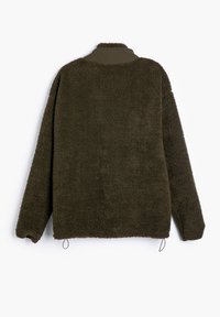 Chaqueta de forro polar marrón con cuello alto, superficie texturizada, hombros caídos y cordones elásticos en el dobladillo. Sin herrajes o patrones visibles.