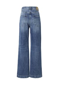 Jean en denim bleu à taille haute, jambes larges, avec deux poches arrière et une étiquette en cuir sur la ceinture.