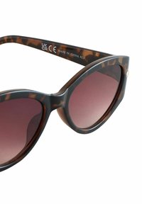 Kaķa acu formas saulesbrilles ar bruņurupuču rakstu un gradienta lēcām. Matēts pārklājums ar spīdīgiem akcentiem uz kājiņām; marķētas ar CE un UKCA etiķetēm.