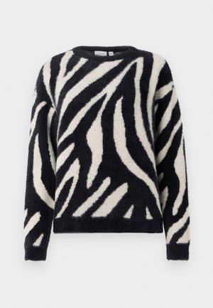 Czarny i kremowy sweter w paski o puszystej fakturze, okrągłym dekolcie i długich rękawach. Wzór przypomina paski zebry na tkaninie.