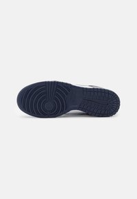 Tengerészeti gumis sneaker talp körkörös futófelületekkel, oldalsó hornyokkal és a középtalpon bemélyesztett "Nike" logóval.