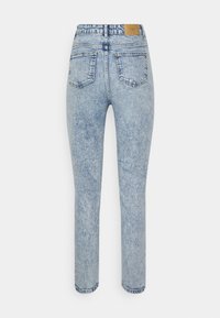 Jeans de denim azul claro com um design de perna reta, apresentando dois bolsos traseiros e uma etiqueta bordada na cintura. Textura desbotada por todo o tecido.