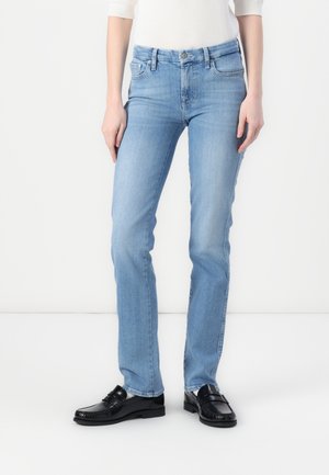 Svetlo modri jeans s slim fit krojem, pet žepnim dizajnom, ki vključuje gumb za zapiranje in zanke za pas. V kombinaciji z črnimi usnjenimi loaferji.