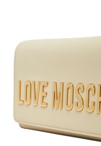 Borsa a mano in pelle beige con texture liscia e lettering dorato "LOVE MOSCHINO" sul frontale. Forma rettangolare con bordi cuciti.