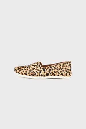 Slip-On-Flacher Schuh mit Leopardenmuster und weißer Sohle, seitlich auf hellem, einfarbigem Hintergrund gezeigt.