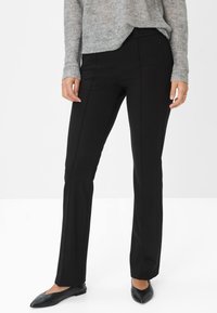 Zwarte op maat gemaakte broek met een recht model, gemaakt van een gladde stof met subtiele zijpanelen. Draagt men met een grijs gestructureerd sweater.