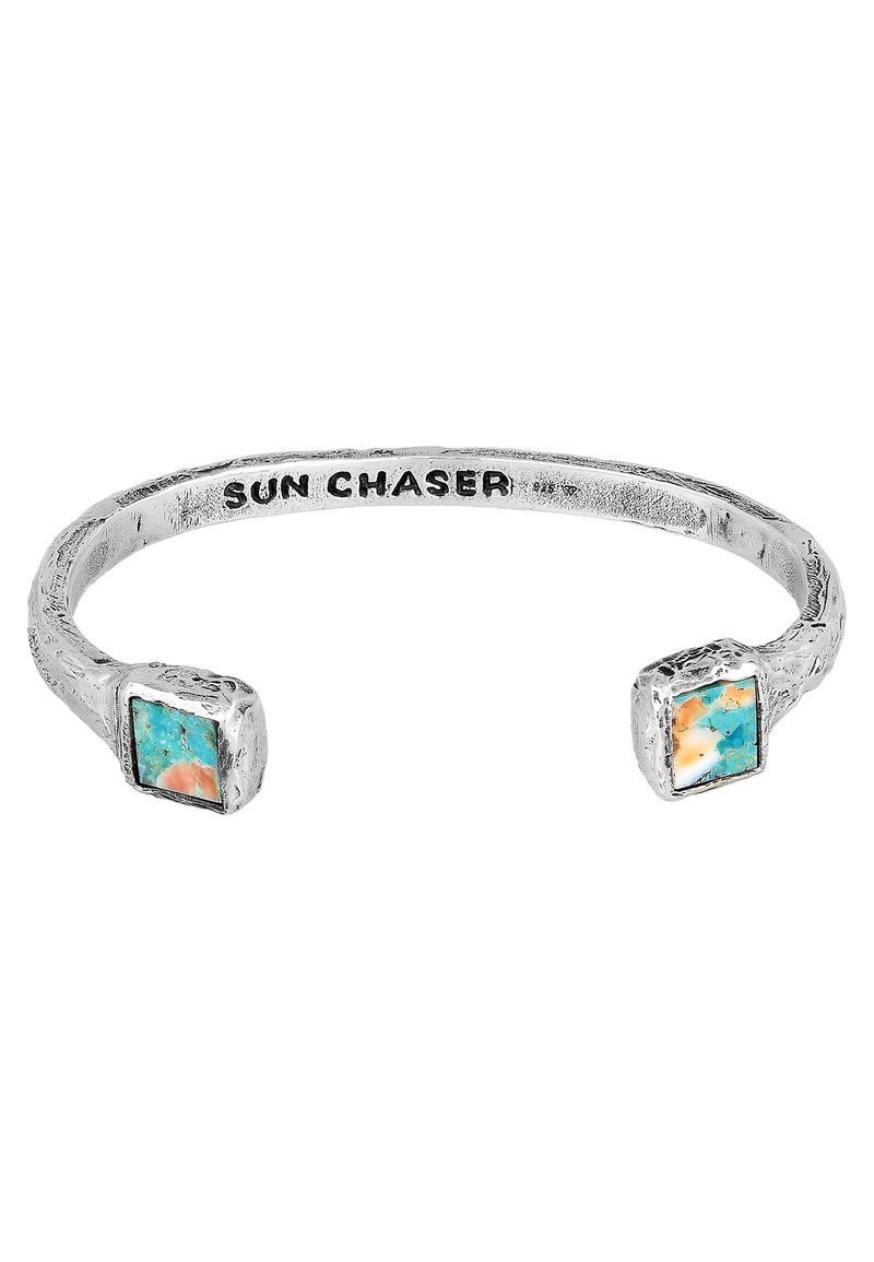 Silver armband med fyrkantiga turkosa och orange stenar i varje ände, med en texturerad yta och graverad "SUN CHASER."