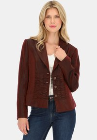 Bordowa, dopasowana kurtka z teksturowanym przodem z falbankami, z wyłogami oraz trzema guzikami z przodu. Nosi się ją na białej bluzce.