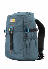 Mochila de tejido verde azulado con acentos de cuero marrón, correas de malla negra y herrajes azules. Cuenta con un bolsillo lateral y correas ajustables.