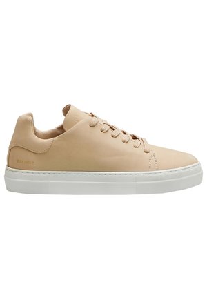 Baskets basses en cuir beige avec fermeture à lacets et semelle épaisse en caoutchouc blanc, embossées côté avec "EST 2010".