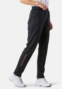 Svarta träningsbyxor i strukturerat tyg, med sidfickor och "SWEDEMOUNT"-logotyp i rosa på underbenet. Elastisk midja.