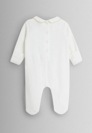 Fehér baba rugdalózó hosszú ujjakkal, kerek gallérral, aranylánc díszítéssel és hátul gombos eldolgozással. Puha anyag.