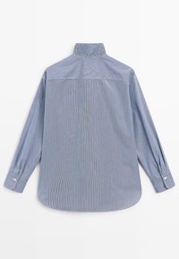 Chemise bleue à manches longues avec de fines rayures verticales, poignets boutonnés et col montant, vue de dos sur fond blanc.